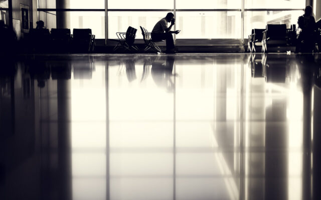 homem dentro do aeroporto sentado sozinho
