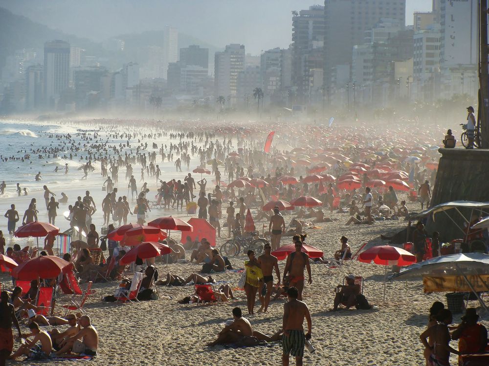 Vista aérea de Copacabana cheia de banhistas e quiosques coloridos verão no Rio de Janeiro - Lets fLY Away